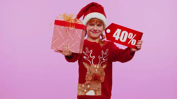 Menina criança em chapéu de Natal mostrando caixa de presente e 40 por cento de desconto inscrições banner nota texto — Fotografia de Stock