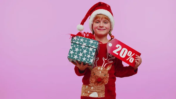 Девочка в рождественской шляпе с подарочной коробкой и 20-процентной надписью на баннере — стоковое фото