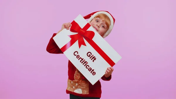 Menina engraçada usa chapéu de Papai Noel de Natal e chapéu de presente de cartão de presente cupom vencedor voucher — Fotografia de Stock