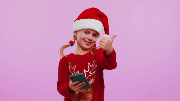 Щаслива дівчина в різдвяному светрі дивиться дисплей смартфона щиро радісно виграє успіх — стокове фото