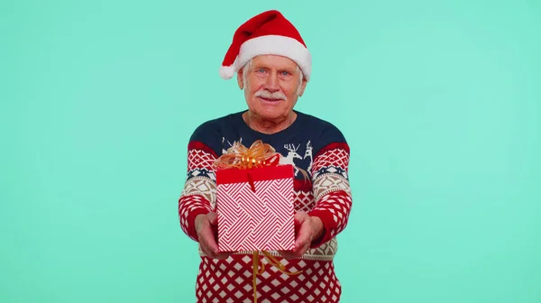 Senior Opa in Silvester Pullover und Hut präsentiert Weihnachtsgeschenkbox, Shopping-Verkauf Feiertage — Stockfoto