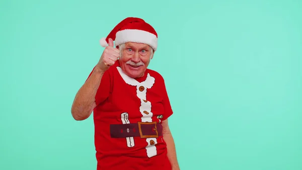 Старший різдвяний дідусь радісно посміхається, вказуючи на камеру, красуня вибирає щасливого переможця — стокове фото