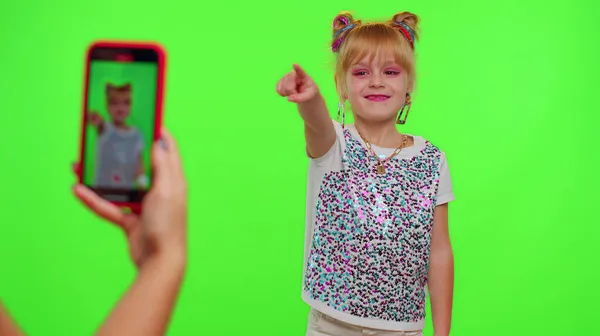 Glada rolig liten tonåring flicka unge dansa vid kameran filma video med hjälp av telefon på chroma nyckel vägg — Stockfoto