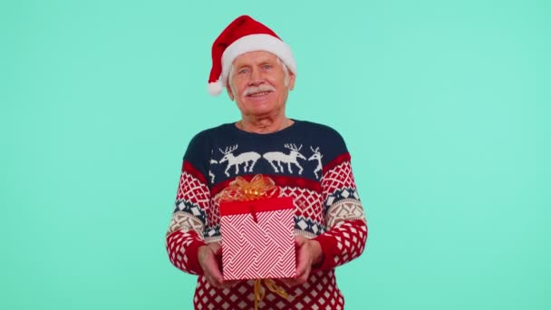 Senior grootvader man draagt nieuwjaar trui presenteren kerstcadeau doos, winkelen vakantie — Stockvideo