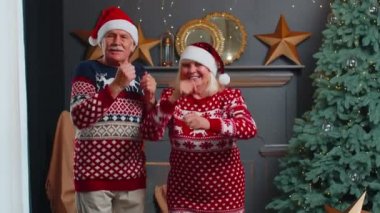 Yaşlı çift büyükannem Noel ağacıyla süslenmiş bir odada dans ediyor.