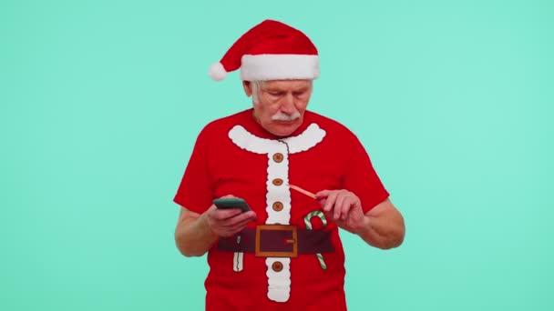 Senior Christmas kakek pria menggunakan kartu kredit, smartphone mentransfer uang belanja online — Stok Video