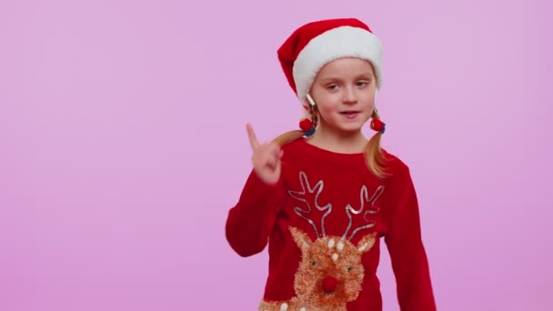 Meisje in de kerst trui luisteren muziek via oortjes, dansen disco rommelen met plezier — Stockvideo