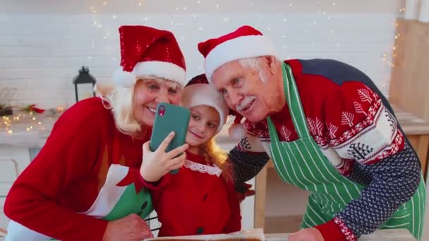 Grandparents family with granddaughter kid taking selfie photo on mobile phone at Christmas kitchen — Stock Video