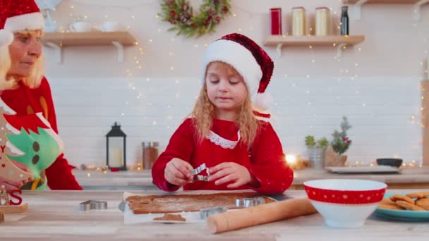 Starsi starzy dziadkowie z wnuczka dziecko przygotowuje, gotowanie ciasteczka w domu Christmas kitchen — Wideo stockowe