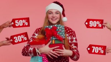 Hediye kutuları tutan ve Noel indirimleri alan bir kız. Yazılar, alışveriş satışı.