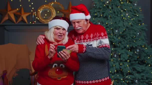 Dojrzała babcia rodziny przy użyciu karty kredytowej i smartfona zakupy prezenty świąteczne — Wideo stockowe
