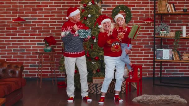 Щаслива старша стара пара бабусь і дідусів з онукою святкують танці біля ялинки — стокове відео