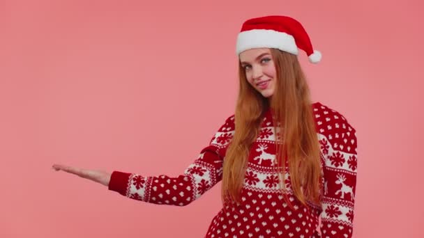 Mujer lleva rojo Año Nuevo suéter ciervo mostrando pulgares hacia arriba y señalando en el espacio de publicidad en blanco — Vídeos de Stock
