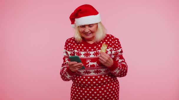 Старшая женщина Рождество бабушка с помощью кредитной карты, смартфон передачи денег покупки в Интернете — стоковое видео