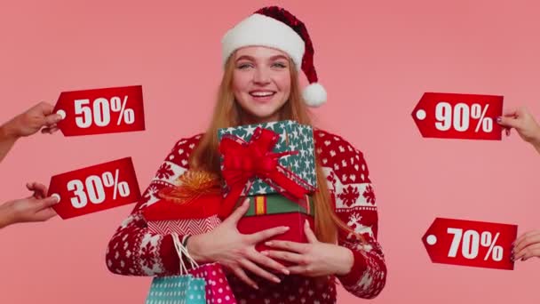 Chica sosteniendo cajas de regalo y recibir descuentos de Navidad inscripciones banner textos, venta de compras — Vídeo de stock