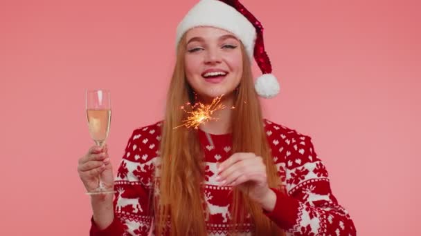 Lovely girl in Christmas Santa sweater dancing with bengal sparklers fireworks and champagne glass — Stock Video