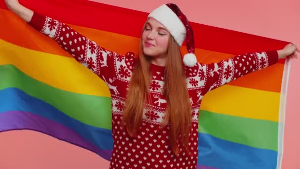 Flicka i jultröja poserar med regnbåge flagga fira parad tolerans samma kön äktenskap — Stockvideo