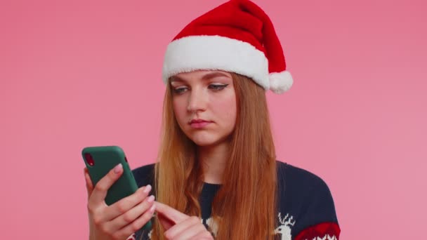 Mulher em elegante camisola de Natal olhando exibição smartphone sinceramente regozijando-se ganhar sucesso sorte — Vídeo de Stock