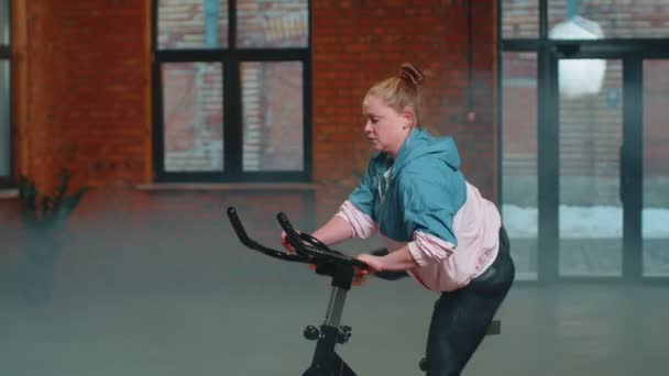 Donna esegue allenamento aerobico di resistenza allenamento cardio routine sui simulatori, ciclo di allenamento — Video Stock