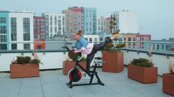 Žena provádí aerobní trénink vytrvalosti kardio rutiny na simulátorech, cyklistický trénink — Stock video