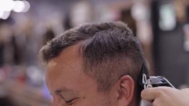 Berber saç kesimi elektrikli makasla, berber berber berber dükkanında damadın saçını kesiyor.