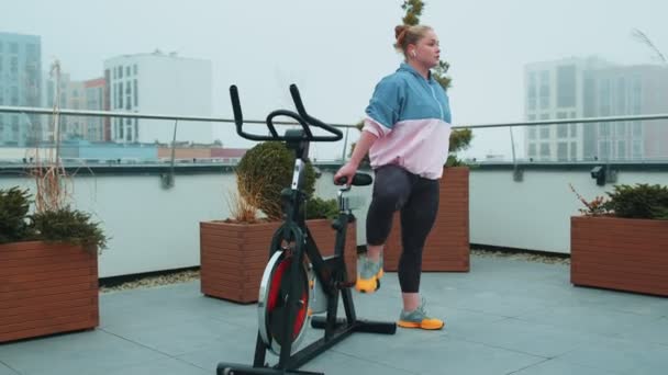 Woman performs aerobic endurance training workout cardio routine on the simulators, cycle training — Stock Video