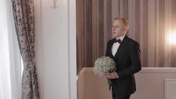 Groom with wedding bouquet in his hands at home preparing to go to bride, portrait slow motion — Vídeo de Stock