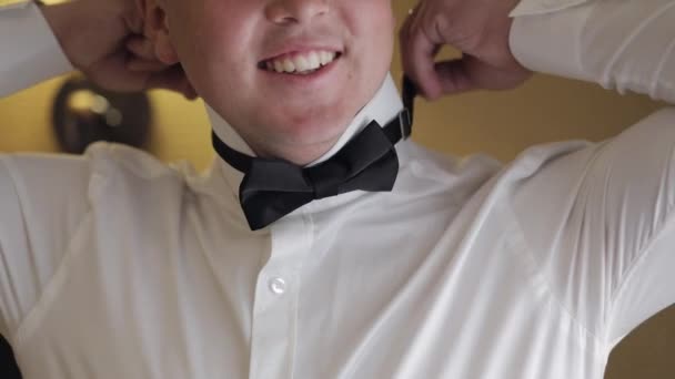 Наречений чоловік коригує краватку, готуючись піти на наречену, бізнесмен в білій сорочці, день весілля — стокове відео