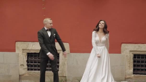 Nygifta, vackra bröllop kaukasiska brud och brudgum dansar trendig dans firar på stadens gata — Stockvideo