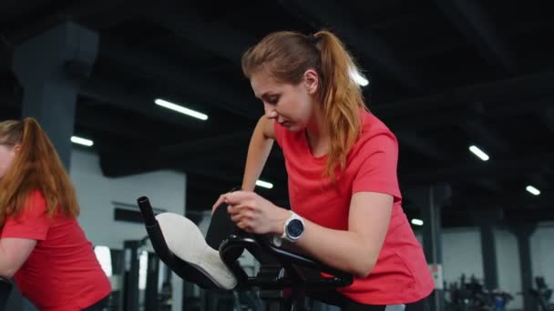 Csoportja lányok elvégzi nyújtás edzés edzés kardio rutin kerékpár szimulátorok ciklus képzés — Stock videók