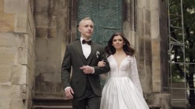 Yeni evliler, beyaz damat, yürüyen, kucaklayan, şehirde kucaklayan, aşık düğün çifti.