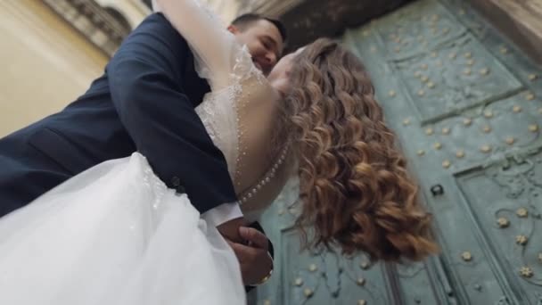 Newlyweds, caucasian groom with bride walking, embracing, hugs on the city street, wedding couple — Stockvideo