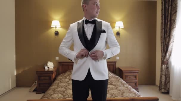 Groom buttoning jacket, man in suit fastens buttons on his jacket preparing to go out — Vídeo de Stock