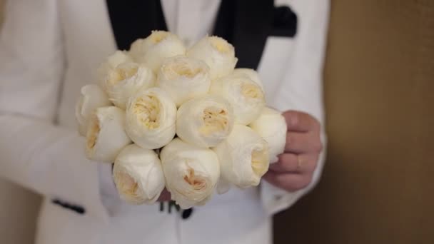 Vőlegény esküvői csokorral a kezében otthon készül a menyasszonyra, közelkép lassított felvétel — Stock videók