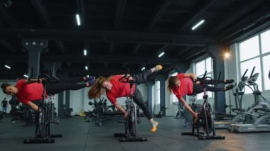 Spor salonunda spor yapan atletik kadınlar, spor salonunda bisiklet çevirme numaraları, kapalı alanda kilo verme.