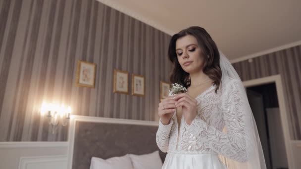 Νύφη σε λευκό φόρεμα που μένει με γυψόφυλλες λουλούδια μπουκέτο περιμένει τον γαμπρό, το πρωί του γάμου — Αρχείο Βίντεο