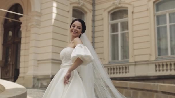 Gyönyörű és szép menyasszony esküvői ruha és fátyol közelében régi vár a vőlegény, lassított felvétel — Stock videók