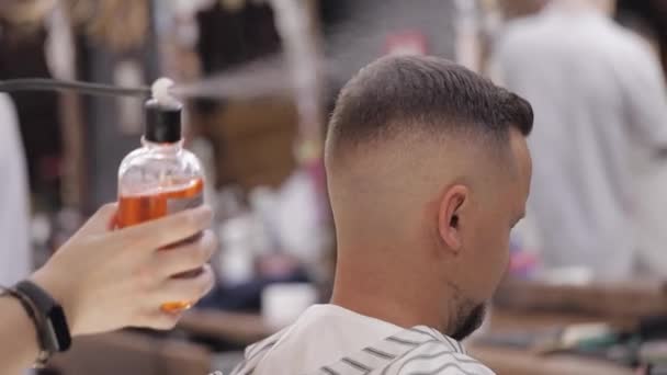 Barber spray perfume from bottle on customer hair, barber makes haircut for groom man at barber shop — 图库视频影像