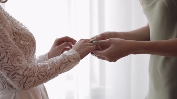 Νύφη φίλες παράνυμφος κρατώντας το χέρι της γυναίκας στο νυφικό στο σπίτι διαμέρισμα κοντά στο παράθυρο — Αρχείο Βίντεο