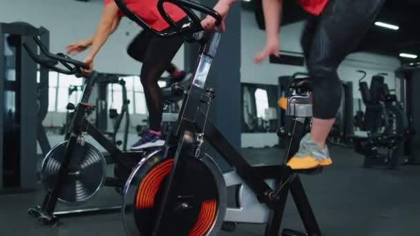 Group of girls performs aerobic training workout cardio routine on bike simulators, cycle training — Stockvideo