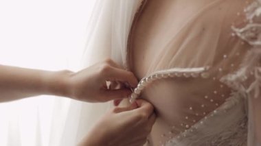 Nedime kravatları ve gelinliği giymeye yardım etmek, gelinin beyaz elbisesiyle sabah hazırlığı.