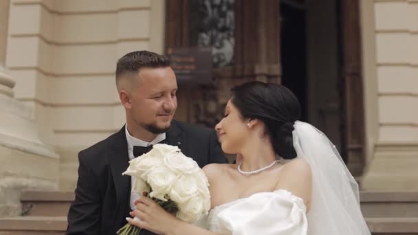 Newlyweds portrait, caucasian groom bride walking, embracing, hugs near old castle, wedding couple — Stockvideo