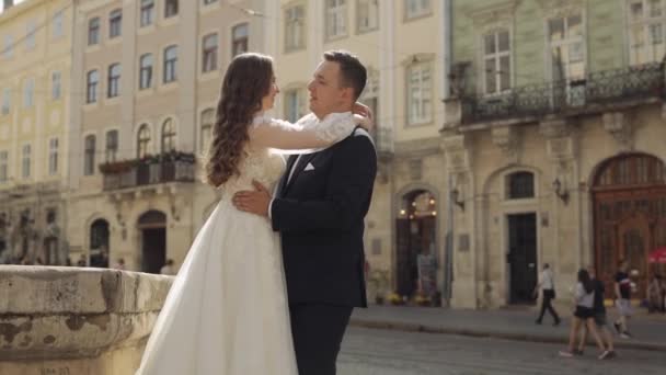 Nygifta, kaukasiska brudgum med brud promenader, omfamning, kramar på stadens gata, bröllop par — Stockvideo