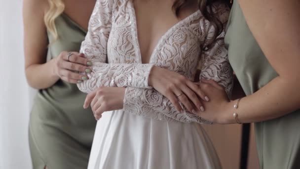 Novias novias damas de honor en ayuda a la mujer a ponerse el vestido de novia, de la mano, abrazo, abrazo — Vídeos de Stock