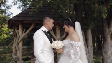 Yeni evliler, beyaz damat, yürüyen, kucaklaşan, parkta kucaklaşan, aşık düğün çifti.