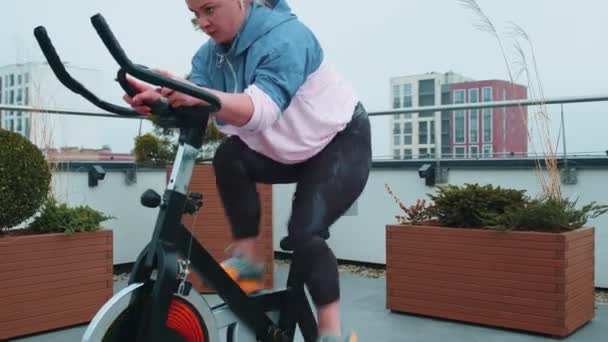 Kobieta wykonuje aerobowy trening wytrzymałościowy cardio rutynowy na symulatorach, trening rowerowy — Wideo stockowe