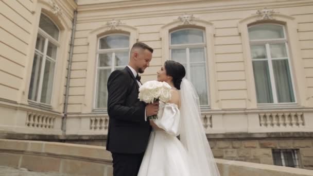 Friss házasok portré, fehér vőlegény menyasszony séta, ölelés, ölelés mellett régi kastély, esküvő pár — Stock videók