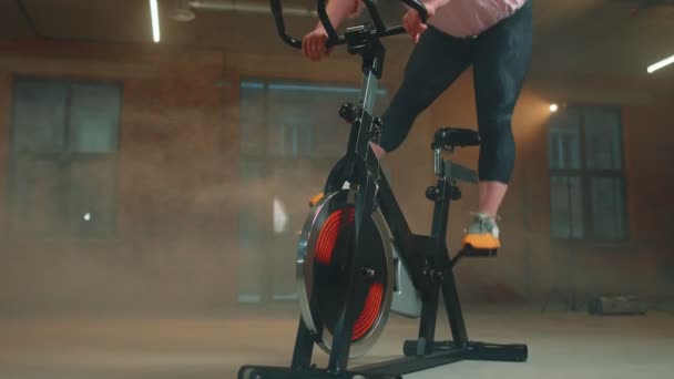 Mujer realiza entrenamiento de resistencia aeróbica rutina de entrenamiento cardiovascular en los simuladores, entrenamiento de ciclo — Vídeo de stock