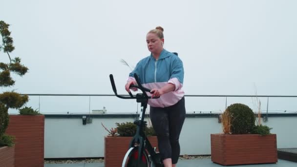Donna esegue allenamento aerobico di resistenza allenamento cardio routine sui simulatori, ciclo di allenamento — Video Stock