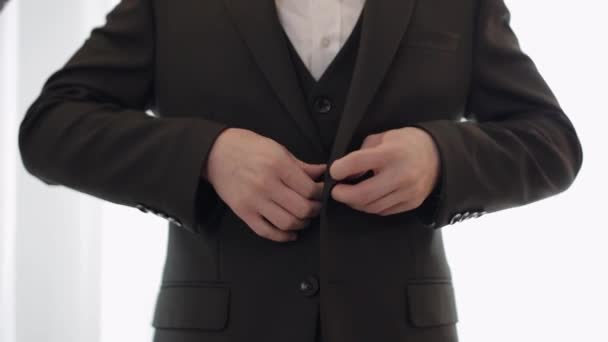 Піджак для кнопок для нареченого, чоловік у костюмі застібає кнопки на піджаку, готуючись вийти — стокове відео